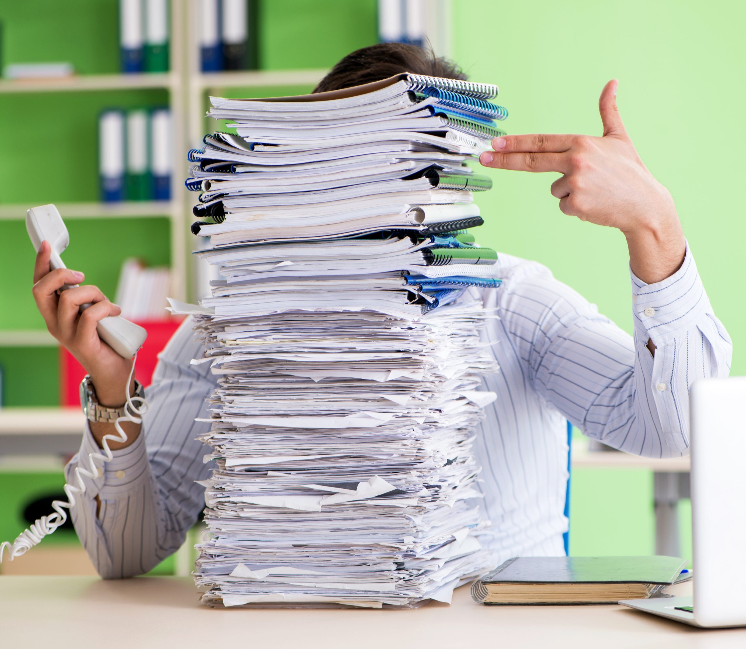 Businessman having problems with paperwork and workload